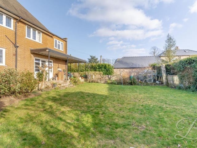 As we step outside, this is your first glimpse of the enclosed garden at the back of the house. Assets include a vegetable patch and a greenhouse.