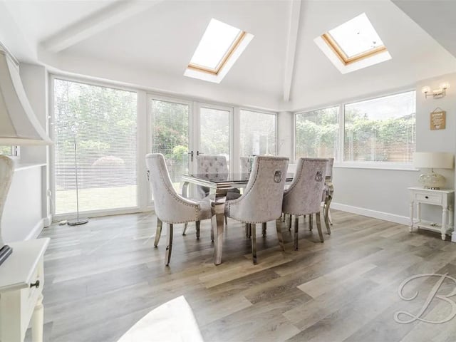 The dining space is filled with natural light from Velux windows, surrounding glazing, and double doors that open out to the garden.