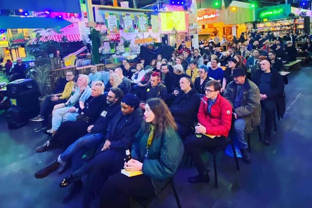 Audiences attend the book launch at Tooting Hill Market, London.
