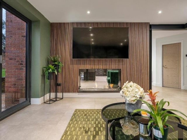 The lounge is typical of the sleek and stylish design of the whole property. There are metre-square floor tiles and a modern, full-height radiator, as well as ceiling spotlights..