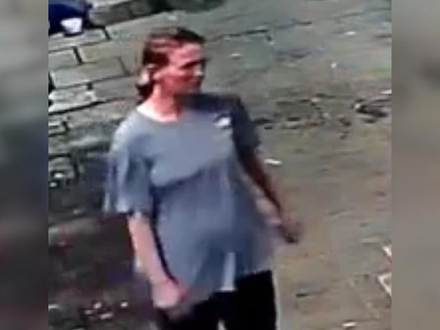 Female with brown hair tied back, grey/blue long t-shirt, black joggers with a stripe down the leg.