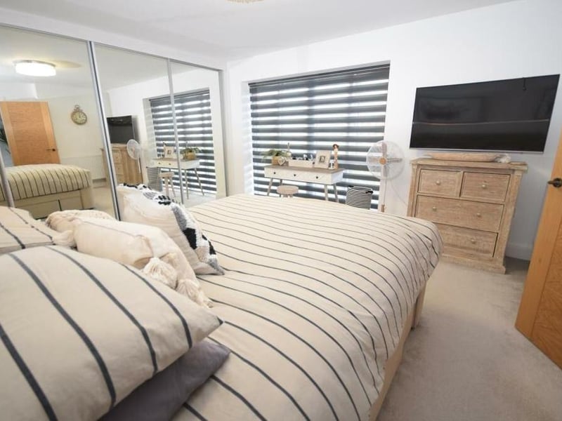 The master bedroom is bathed in natural light thanks to the large window. There is also ample room for furniture, as well as a big-screen TV.