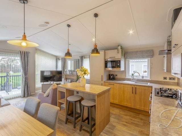 The hub of the home is this open-plan kitchen/dining room, which includes sliding doors that lead out to the front of the property.