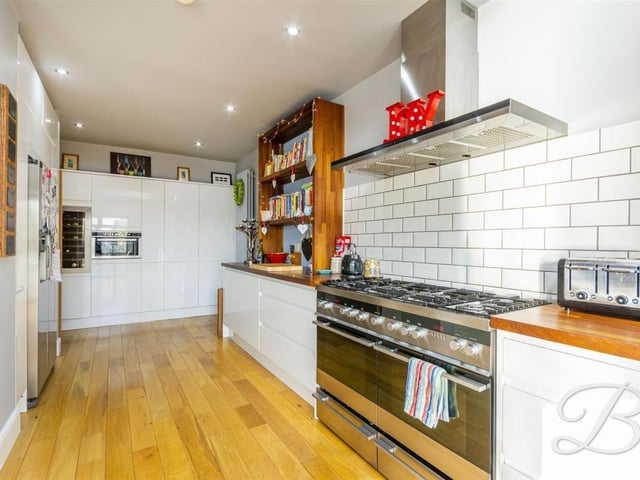 The kitchen comes complete with a range of modern gloss units and cabinets with complementary work surface over and inset sink.
