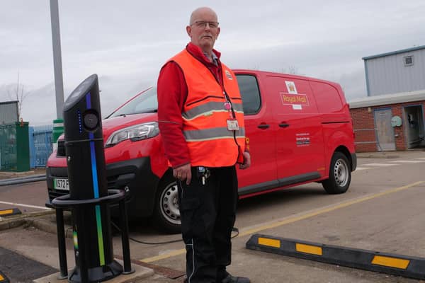 Mansfield Delivery Office postman, Dean Walters, stands alongside one of the new EVs at the site