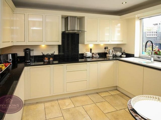 The breakfast kitchen is fitted with shaker-style wall and base units. Integrated appliances include a waist-height double oven, electric hob with extractor over, and dishwasher. Ceiling spotlights and tiled flooring add to the appearance of the room, while a window faces the back garden. Just off the kitchen is a utility room.