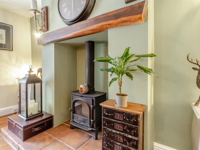 Like the lounge, the dining room includes a feature fireplace. It comprises a log burner with tiled hearth and oak mantle above.