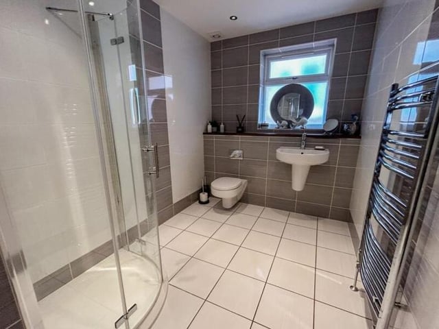 This is the second attractive bathroom on the first floor of the house. A shower cubicle is complemented by a wash hand basin, low-flush WC and chrome, heated towel-rail.