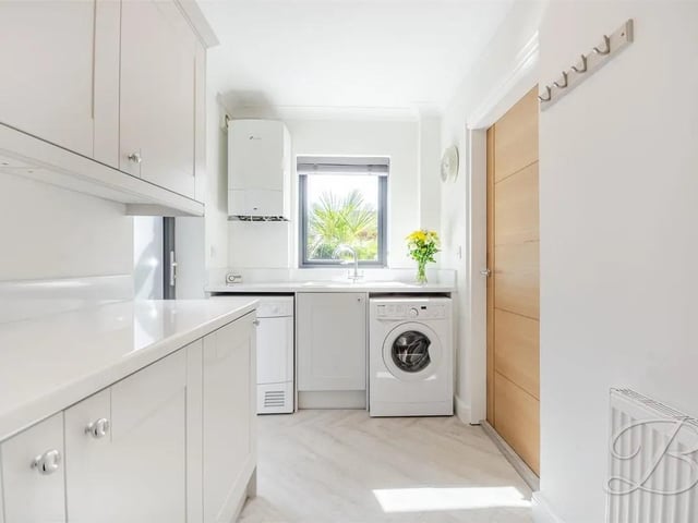 Fully equipped with a comprehensive range of cabinetry, an inset sink with drainer, and generous worktop space for added practicality. The room also offers dedicated space and plumbing for a washing machine and tumble dryer, making it an ideal functional extension to the kitchen.