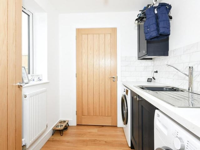 Just off the kitchen/diner is this utility room, which has plumbing for a washing machine and dryer. The room is fitted with wall and base units, plus work surfaces incorporating a stainless steel sink and drainer with mixer tap.