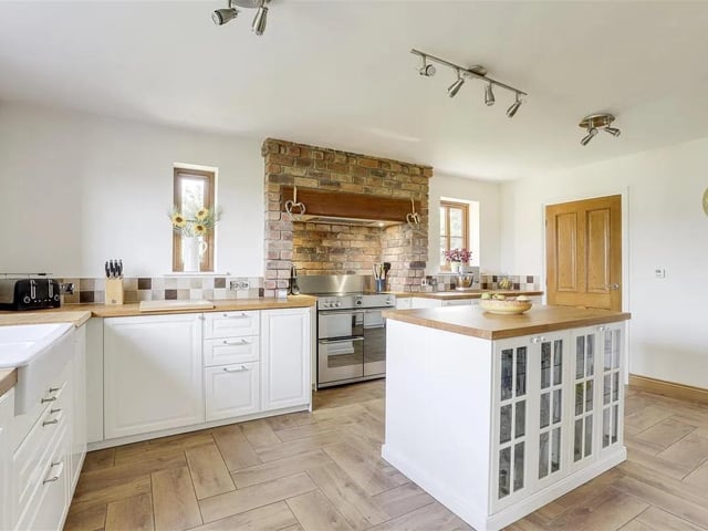 The heart of the home is the bright and airy open-plan kitchen diner, complete with integrated appliances and a striking feature wall of exposed reclaimed brick.