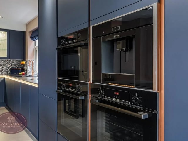 Integrated appliances include waist height double electric oven, microwave, dishwasher, washing machine / tumble dryer, coffee machine, induction hob with extractor over and wine cooler.