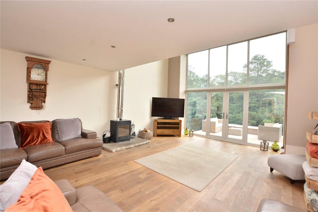 The living room is flooded with natural light thanks to the floor to ceiling windows, and features doors leading out to the outdoor terrace, as well as a log burner for cosy evenings.