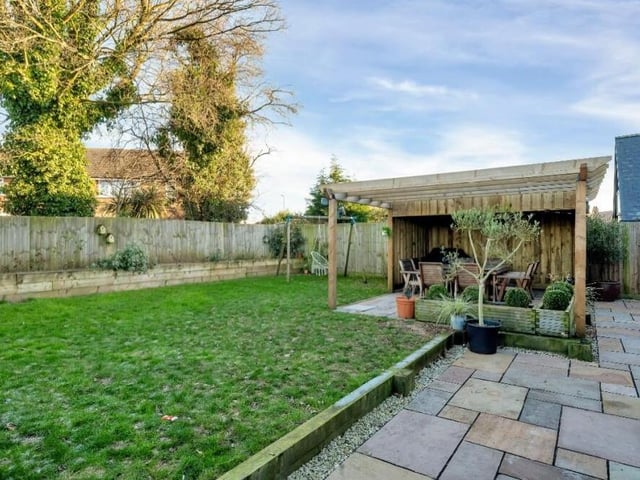 The good-sized back garden features a well-maintained lawn, an Indian sandstone patio and a wooden pergola.