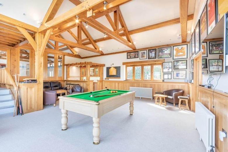 As we move into the stunning leisure complex within the Mansfield Road property, let's start in this magnificent, double-level entertainment and games room, which features a built-in bar.
