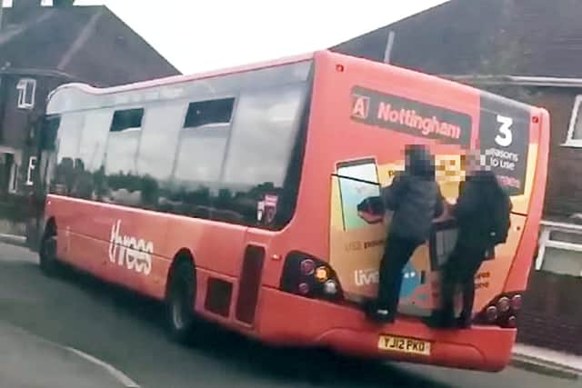 This is the shocking moment two reckless schoolboys hang on to the back of a bus for more than a minute before jumping off in Kirkby. Photo: Elizabeth Todd/SWNS