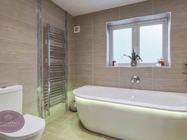 We round off our tour of the interior with a peek at the luxurious family bathroom on the first floor. A three-piece suite consists of a Duravit bath with mood lighting, a vanity sink unit with mirror, and a WC. A chrome, heated towel-rail, ceiling spotlights, porcelain tiled walls and floor, and underfloor heating add to the ambience.