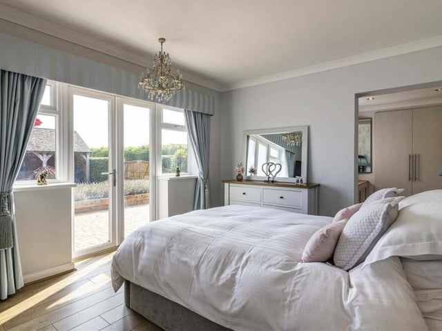 It's time to check out the four bedrooms now, starting with the masterful master, where large French doors lead to the garden. It also has its own private dressing room and en suite shower room.