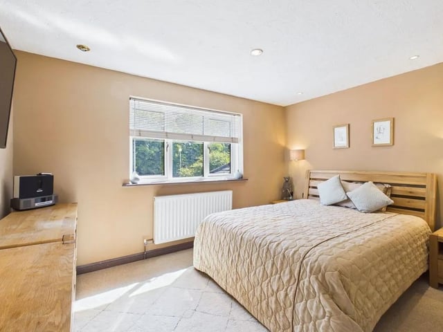 The luxurious main bedroom suite acts as a private sanctuary, boasting a walk-in dressing room with an open wardrobe system, further built-in wardrobes with sliding doors and a private en suite bathroom.