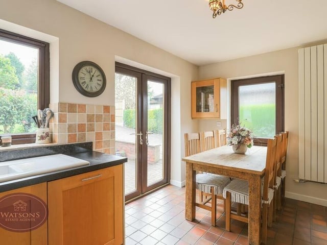 At one end of the open-plan kitchen is this dining section, with space for a dining/breakfast table in front of doors that give access to, and views of, the rear garden. There are also two modern vertical radiators.