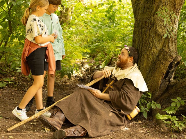 Friar Tuck shares a joke with two young visitors to Sherwood Forest on Sunday, July 30.
