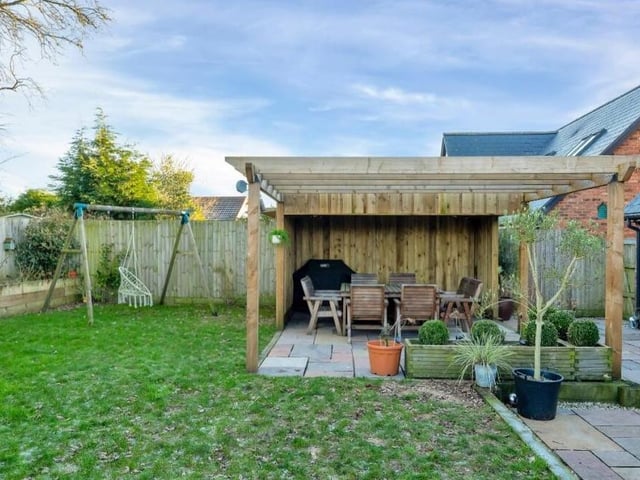 This chunky wooden pergola, with partly covered seating area, makes for an ideal space for entertaining family and friends all year round.