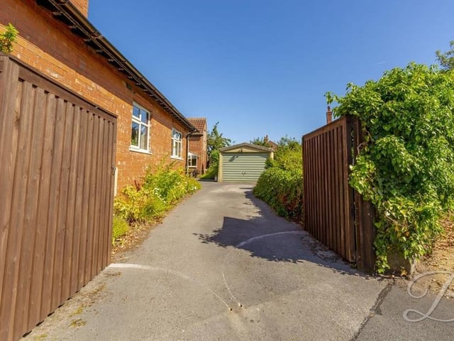 The long driveway that leads to the garage. Off-street parking space is not a problem at this bungalow.