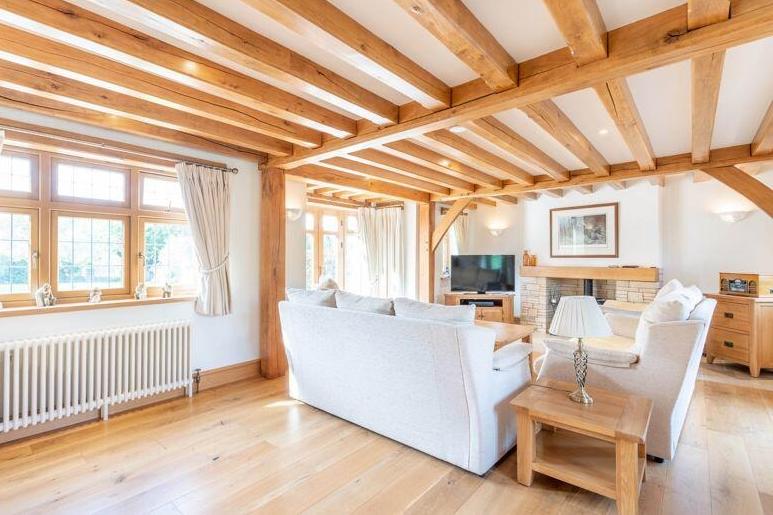 Here is the salubrious sitting room, with its oak flooring and feature fireplace.The oak beamed ceiling is typical of the property.