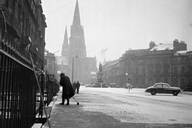 A resident clears the pavement of snow in Melville Street in 1962.