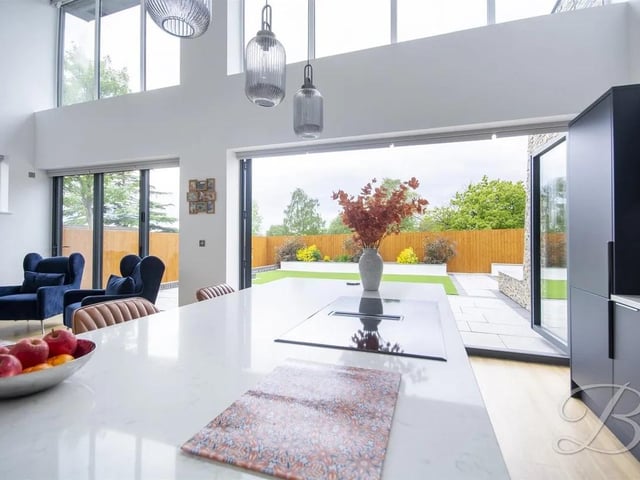 The bi-folding doors open seamlessly onto the rear garden, creating an effortless connection between indoor and outdoor living and bathing the space in natural light