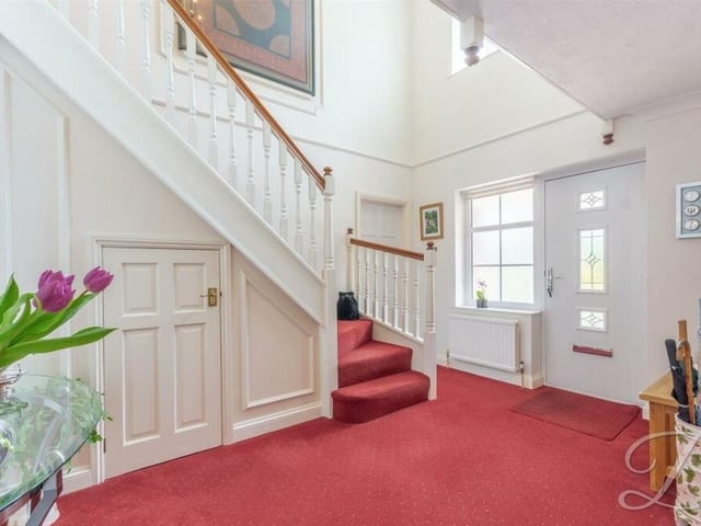 It's time to go upstairs now, which means passing through the entrance hallway. A welcoming space, it features fitted carpets and an under-stairs cupboard.;