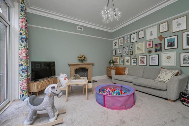 The second large reception room on the ground floor is this characterful family room. It also boasts a stone fireplace, with slate hearth and period-style tiling. Two uPVC, double-glazed patio doors lead out on to the front terrace.