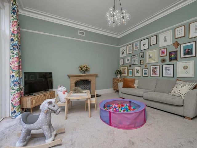 The second large reception room on the ground floor is this characterful family room. It also boasts a stone fireplace, with slate hearth and period-style tiling. Two uPVC, double-glazed patio doors lead out on to the front terrace.