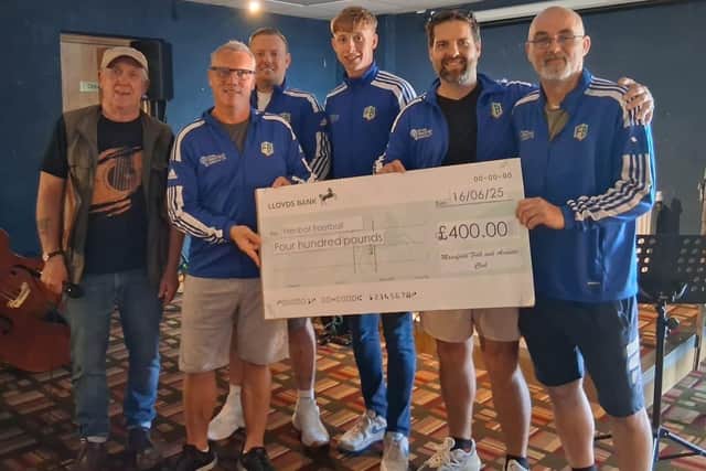 Rob Harley, MC at Mansfield Folk and Acoustic Club, is pictured presenting the cheque to members of the Frenbot team.