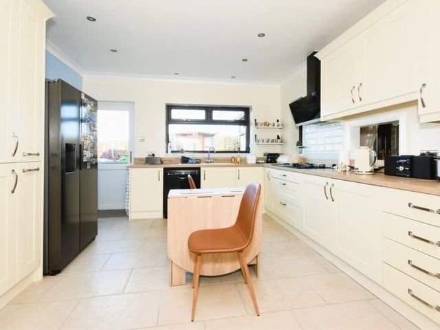 The sparkling kitchen from a different angle. Nearby is a utility room, which has additional storage and also plumbing for a washing machine and tumble dryer.