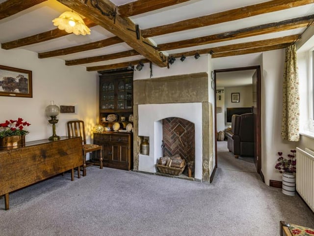 The dining room exudes character and charm, especially with its original fireplace and exposed wooden beams to the ceiling. It is a cosy space for hosting dinner parties or family gatherings.