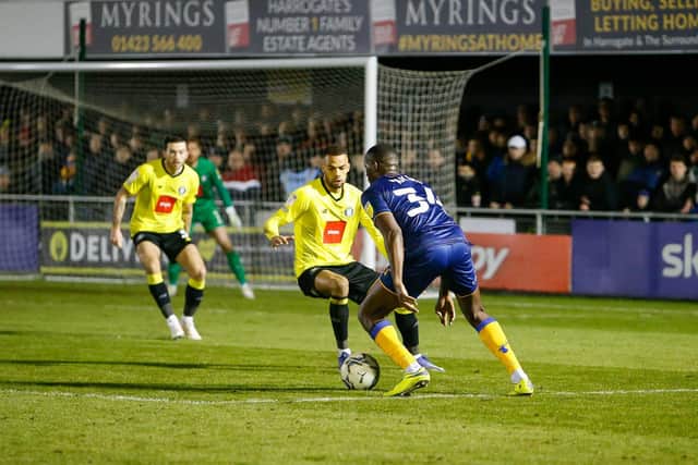 Mansfield Town forward Lucas Akins looks for a way past the Harrogate defence. Photo by Chris Holloway/The Bigger Picture.media