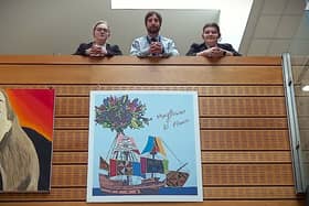 From left, Shirebrook Academy student Molly Holmes, 16, head of art Nick Freer and Freya Scott, 15, with the school’s print of artist Yinka Shonibare’s 2020 painting Mayflowers, All Flowers.