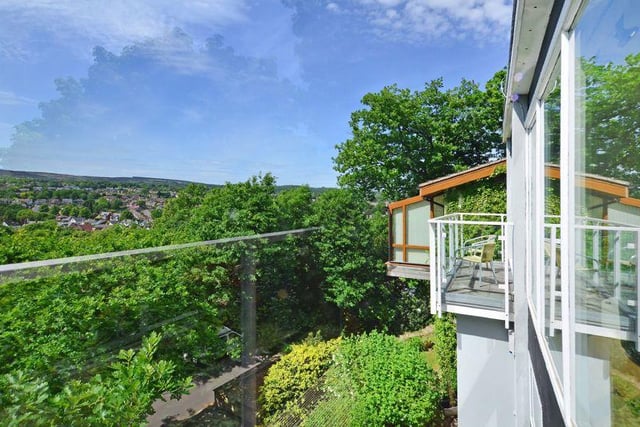 Large glass windows and balconies take advantage of a westerly facing front aspect, with views above the tree line towards Blacka Moor.