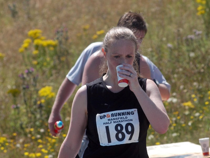 A runner has a water break during the Mansfield Half Marathon in 2018.
