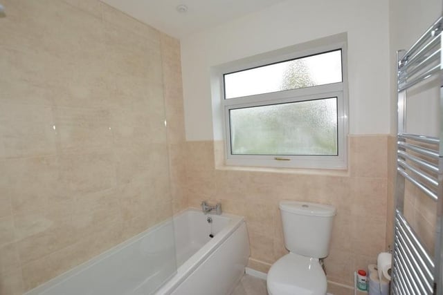 The main bathroom sits on the ground floor of the Honing Drive property. It is newly fitted with a white three-piece suite that comprises a panelled bath with Triton shower over, a pedestal wash hand basin, low-level WC, half-tiled walls, a heated towel-rail and downlighting.