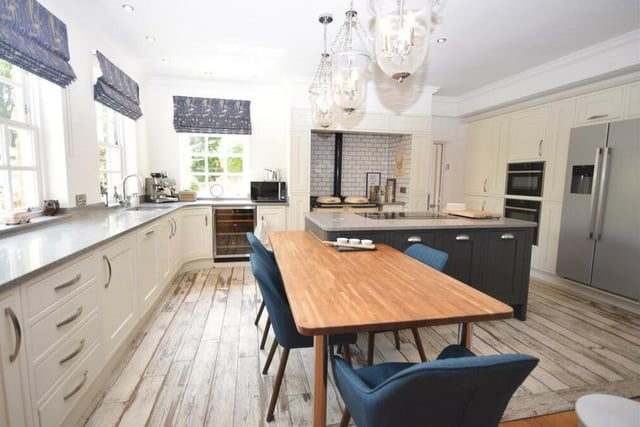 The large bespoke kitchen is a fabulous space, styled in a contemporary manner. It is fitted with a range of elegant wall and base units, complementing work surfaces, while there is room for a dining table.