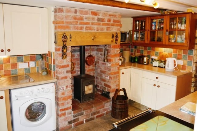 Like the lounge, the characterful kitchen also has an inglenook fireplace with brick-built surround and a cast-iron, multi-fuel burning stove.