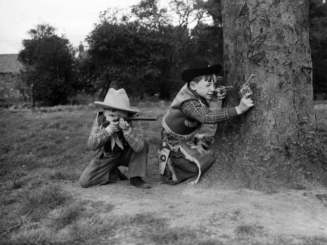 Cowboys Douglas Currie and Jimmy Graham playing with their toy guns at The Inch in Edinburgh.