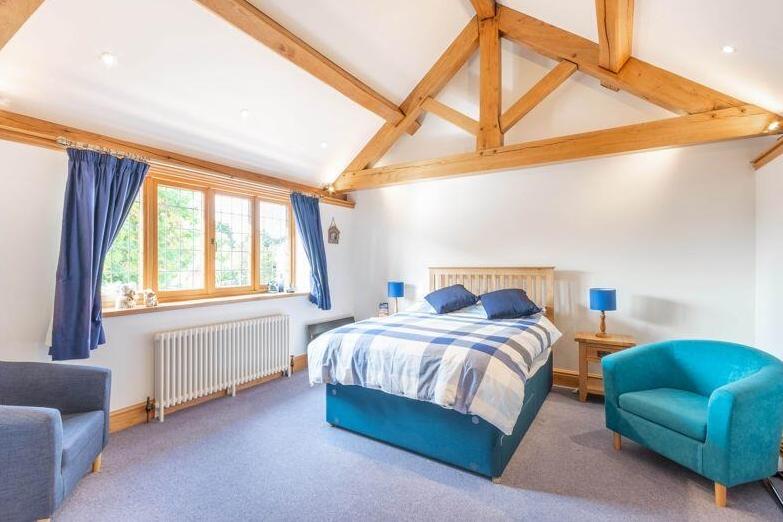 All four bedrooms on the first floor are relaxing, comfortable spaces, including this one. The master boasts a dressing area and a Juliet balcony that overlooks the rear garden.
