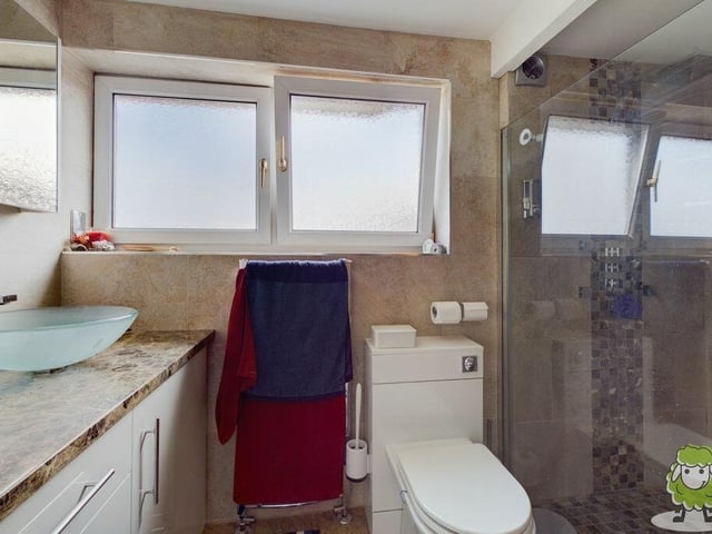 A large shower cubicle and double sinks are the main features of the en suite to the master bedroom.