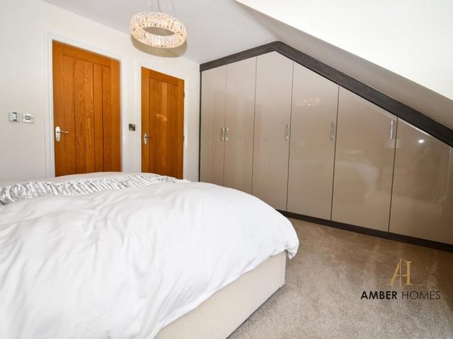 A look at the master bedroom from a different angle, showing an extensive fitted wardrobe.