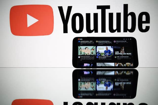 A picture taken on October 5, 2021 in Toulouse shows the logo of Youtube social media displayed by a screen and its website displayed by tablet. ) (Photo by LIONEL BONAVENTURE/AFP via Getty Images)