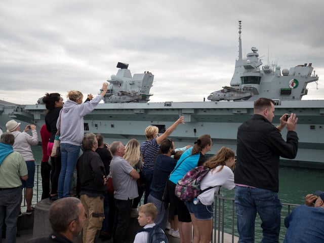People wave from the Round Tower in Old Portsmouth as HMS Queen Elizabeth leaves. Picture: Andrew Matthews/PA Wire