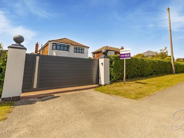 Returning to the front of the Derby Road property, these electrically-controlled gates lead to a carriage driveway.